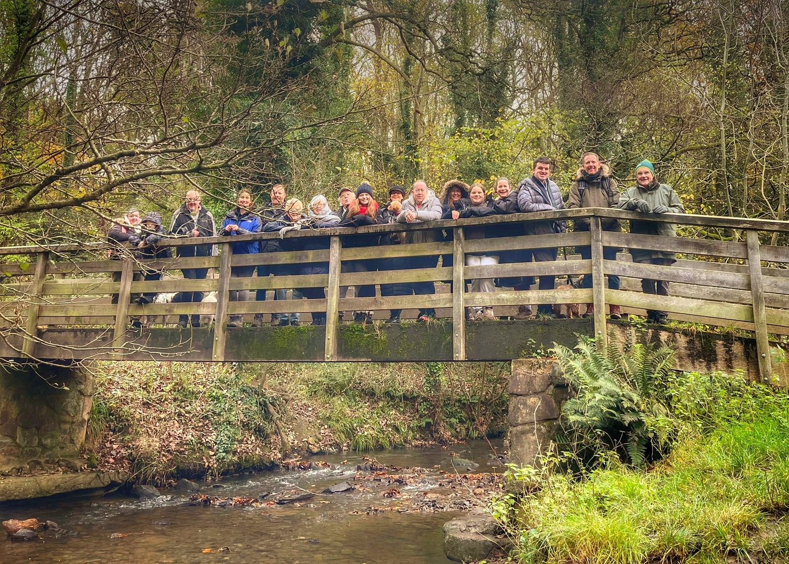 Supporters of Giddo’s Gift on a sponsored walk, waving from a wooden bridge